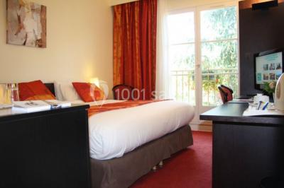 Salle de restaurant élégante avec tables dressées, nappes colorées, chaises modernes et décoration végétale.