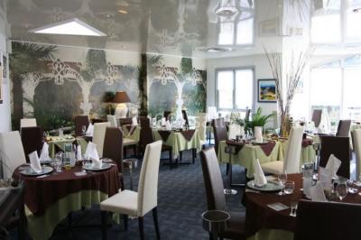 Salle de restaurant élégante avec tables dressées, nappes colorées, chaises modernes et décoration végétale.