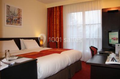 Salle de restaurant élégante avec tables dressées, nappes colorées, chaises modernes et décoration végétale.