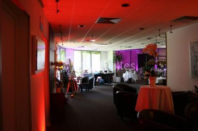 Salle de restaurant élégante avec tables dressées, nappes colorées, chaises modernes et décoration végétale.