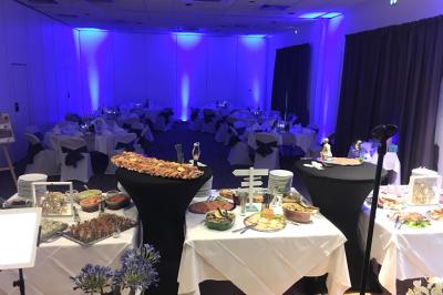 Salle de restaurant élégante avec tables dressées, nappes colorées, chaises modernes et décoration végétale.
