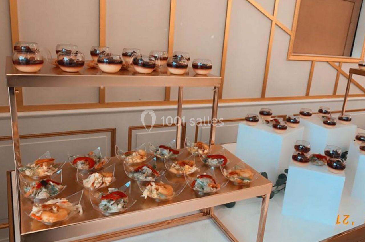 Buffet avec verrines sucrées et salées disposées sur des étagères dorées dans un décor élégant.
