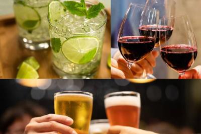 Verres de cocktails variés, dont des shots avec citrons verts et des spritz orange, posés sur des tables en bois.