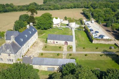 Miniature Location salle Milizac (Finistère) - Domaine de Keranflec'h #17 Structure en bois avec un toit tendu, installée dans un espace extérieur verdoyant et ensoleillé.