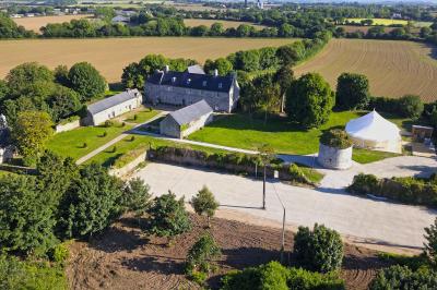 Miniature Location salle Milizac (Finistère) - Domaine de Keranflec'h #12 Structure en bois avec un toit tendu, installée dans un espace extérieur verdoyant et ensoleillé.