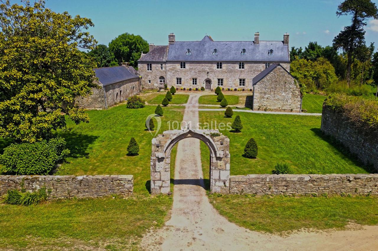Vue aérienne d'un manoir en pierre entouré de jardins, d'une allée centrale et de murs en pierre.