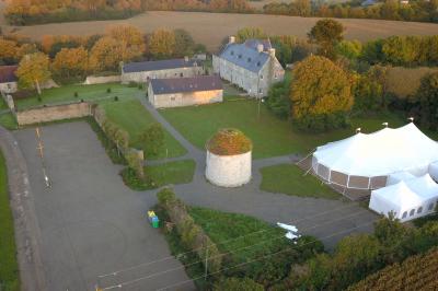 Miniature Location salle Milizac (Finistère) - Domaine de Keranflec'h #18 Structure en bois avec un toit tendu, installée dans un espace extérieur verdoyant et ensoleillé.