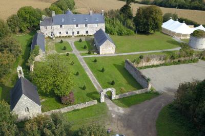 Miniature Location salle Milizac (Finistère) - Domaine de Keranflec'h #21 Structure en bois avec un toit tendu, installée dans un espace extérieur verdoyant et ensoleillé.