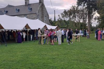 Miniature Location salle Milizac (Finistère) - Domaine de Keranflec'h #31 Structure en bois avec un toit tendu, installée dans un espace extérieur verdoyant et ensoleillé.
