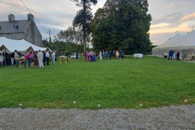 Miniature Location salle Milizac (Finistère) - Domaine de Keranflec'h #32 Structure en bois avec un toit tendu, installée dans un espace extérieur verdoyant et ensoleillé.