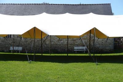 Miniature Location salle Milizac (Finistère) - Domaine de Keranflec'h #54 Structure en bois avec un toit tendu, installée dans un espace extérieur verdoyant et ensoleillé.