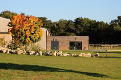 Salle de réception lumineuse avec tables rondes décorées de nappes blanches, fleurs et vaisselle élégante.