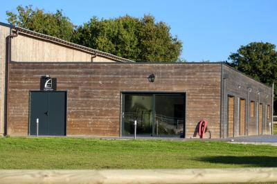 Salle de réception lumineuse avec tables rondes décorées de nappes blanches, fleurs et vaisselle élégante.