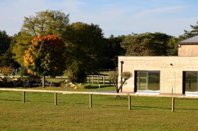 Salle de réception lumineuse avec tables rondes décorées de nappes blanches, fleurs et vaisselle élégante.