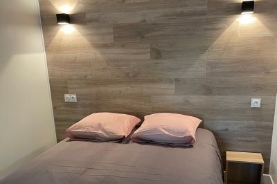 Salle de réception lumineuse avec tables rondes décorées de nappes blanches, fleurs et vaisselle élégante.