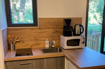Salle de réception lumineuse avec tables rondes décorées de nappes blanches, fleurs et vaisselle élégante.