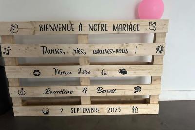 Salle de réception lumineuse avec tables rondes décorées de nappes blanches, fleurs et vaisselle élégante.