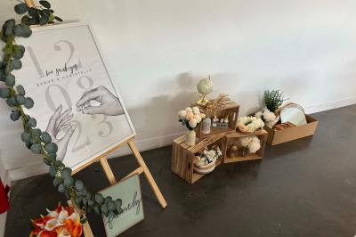 Salle de réception lumineuse avec tables rondes décorées de nappes blanches, fleurs et vaisselle élégante.