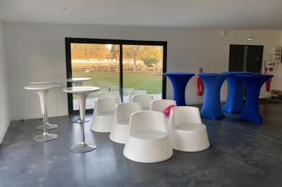 Lit double avec draps gris et oreillers roses, encadré par deux appliques murales sur un mur en bois clair.