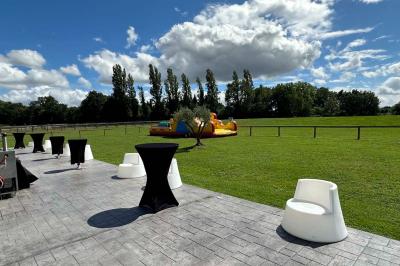 Lit double avec draps gris et oreillers roses, encadré par deux appliques murales sur un mur en bois clair.