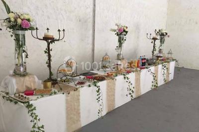 Deux bouteilles de champagne versent simultanément du vin dans une pyramide de coupes en verre.