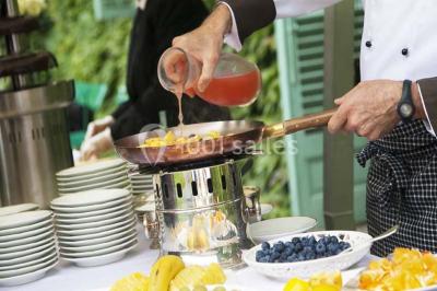 Deux bouteilles de champagne versent simultanément du vin dans une pyramide de coupes en verre.