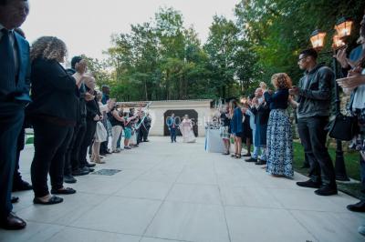 Deux bouteilles de champagne versent simultanément du vin dans une pyramide de coupes en verre.