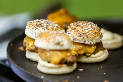 Deux bouteilles de champagne versent simultanément du vin dans une pyramide de coupes en verre.