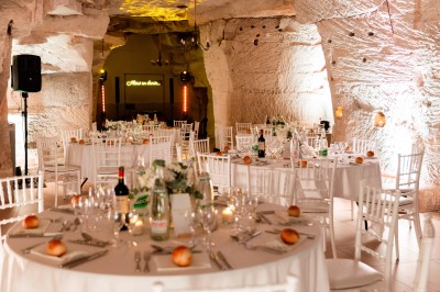 Deux bouteilles de champagne versent simultanément du vin dans une pyramide de coupes en verre.