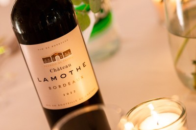 Deux bouteilles de champagne versent simultanément du vin dans une pyramide de coupes en verre.