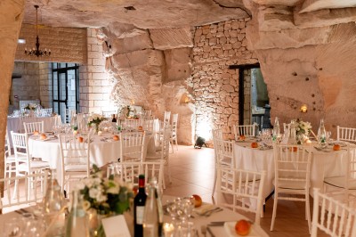 Deux bouteilles de champagne versent simultanément du vin dans une pyramide de coupes en verre.