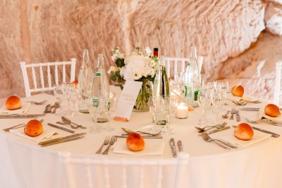 Deux bouteilles de champagne versent simultanément du vin dans une pyramide de coupes en verre.