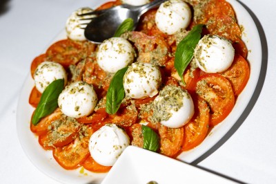 Deux bouteilles de champagne versent simultanément du vin dans une pyramide de coupes en verre.