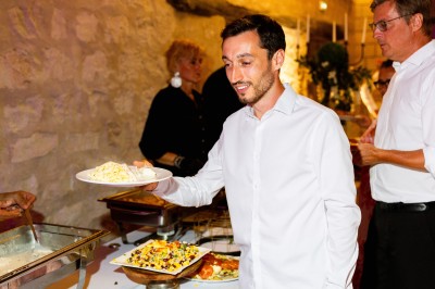 Deux bouteilles de champagne versent simultanément du vin dans une pyramide de coupes en verre.