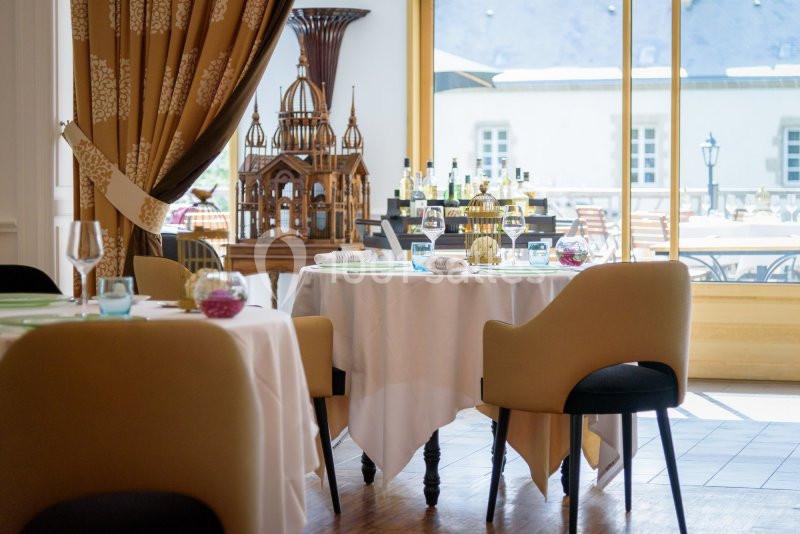 Salle de restaurant élégante avec tables dressées, chaises modernes et vue sur une terrasse ensoleillée.