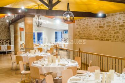 Chambre en bois avec baignoire sur pied, lit double, bureau, fauteuils et grande fenêtre donnant sur l'extérieur.