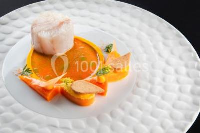 Chambre en bois avec baignoire sur pied, lit double, bureau, fauteuils et grande fenêtre donnant sur l'extérieur.