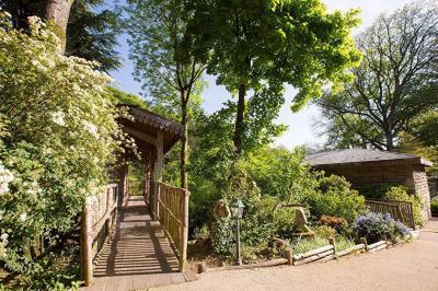 Chambre en bois avec baignoire sur pied, lit double, bureau, fauteuils et grande fenêtre donnant sur l'extérieur.