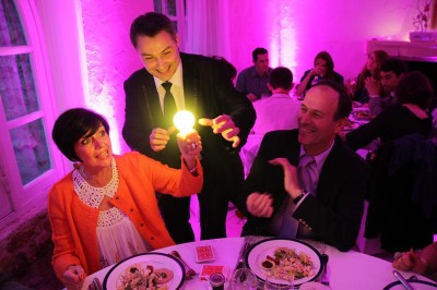 Un homme en costume tenant une tablette affichant des applications, avec un smartphone placé devant l'écran.