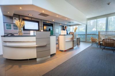 Buffet de petit-déjeuner avec œufs, saucisses, bacon et ustensiles disposés sur un comptoir blanc.