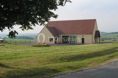 Cuisine professionnelle avec plan de travail en inox, plaques de cuisson, évier et hotte d'extraction.