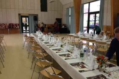 Cuisine professionnelle avec plan de travail en inox, plaques de cuisson, évier et hotte d'extraction.