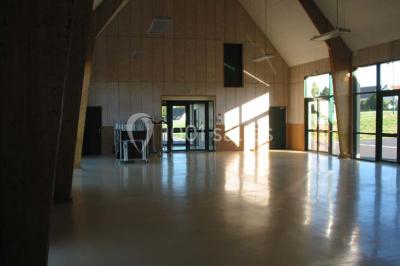 Cuisine professionnelle avec plan de travail en inox, plaques de cuisson, évier et hotte d'extraction.