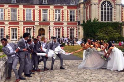 Feu d'artifice illuminant le ciel nocturne au-dessus d'un parc avec des spectateurs rassemblés sur une pelouse.