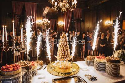 Feu d'artifice illuminant le ciel nocturne au-dessus d'un parc avec des spectateurs rassemblés sur une pelouse.