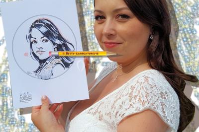 Un homme souriant tient un dessin caricatural de lui-même, réalisé avec des détails humoristiques.