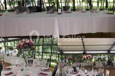 Salle à manger avec table dressée, chaises transparentes, poutre apparente, canapé bleu et tableaux au mur.