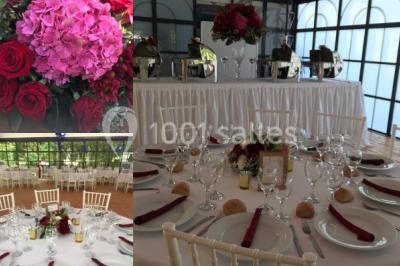 Salle à manger avec table dressée, chaises transparentes, poutre apparente, canapé bleu et tableaux au mur.