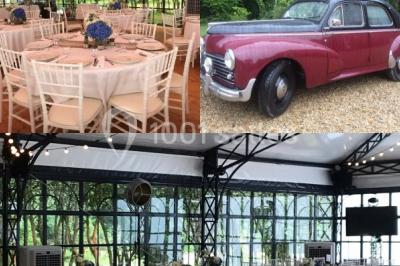 Salle à manger avec table dressée, chaises transparentes, poutre apparente, canapé bleu et tableaux au mur.