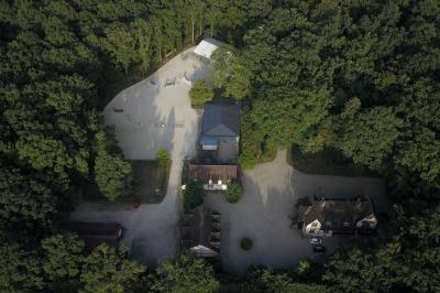 Salle à manger avec table dressée, chaises transparentes, poutre apparente, canapé bleu et tableaux au mur.
